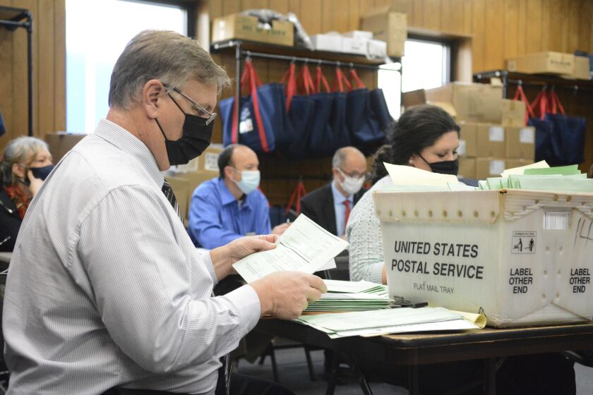 Election Bureau Director Albert L. Gricoski, left, opens provisional ballots alongside election bureau staff Christine Marmas, right, while poll watchers observe from behind at the Schuylkill County Election Bureau in Pottsville, Pa. on Tuesday, Nov. 10, 2020. (Lindsey Shuey/The Republican-Herald via AP)