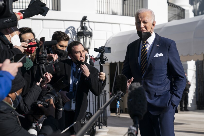 President Joe Biden talks to reporters before boarding Marine One on the South Lawn of the White House, Tuesday, Jan. 11, 2022, in Washington. (AP Photo/Evan Vucci)
