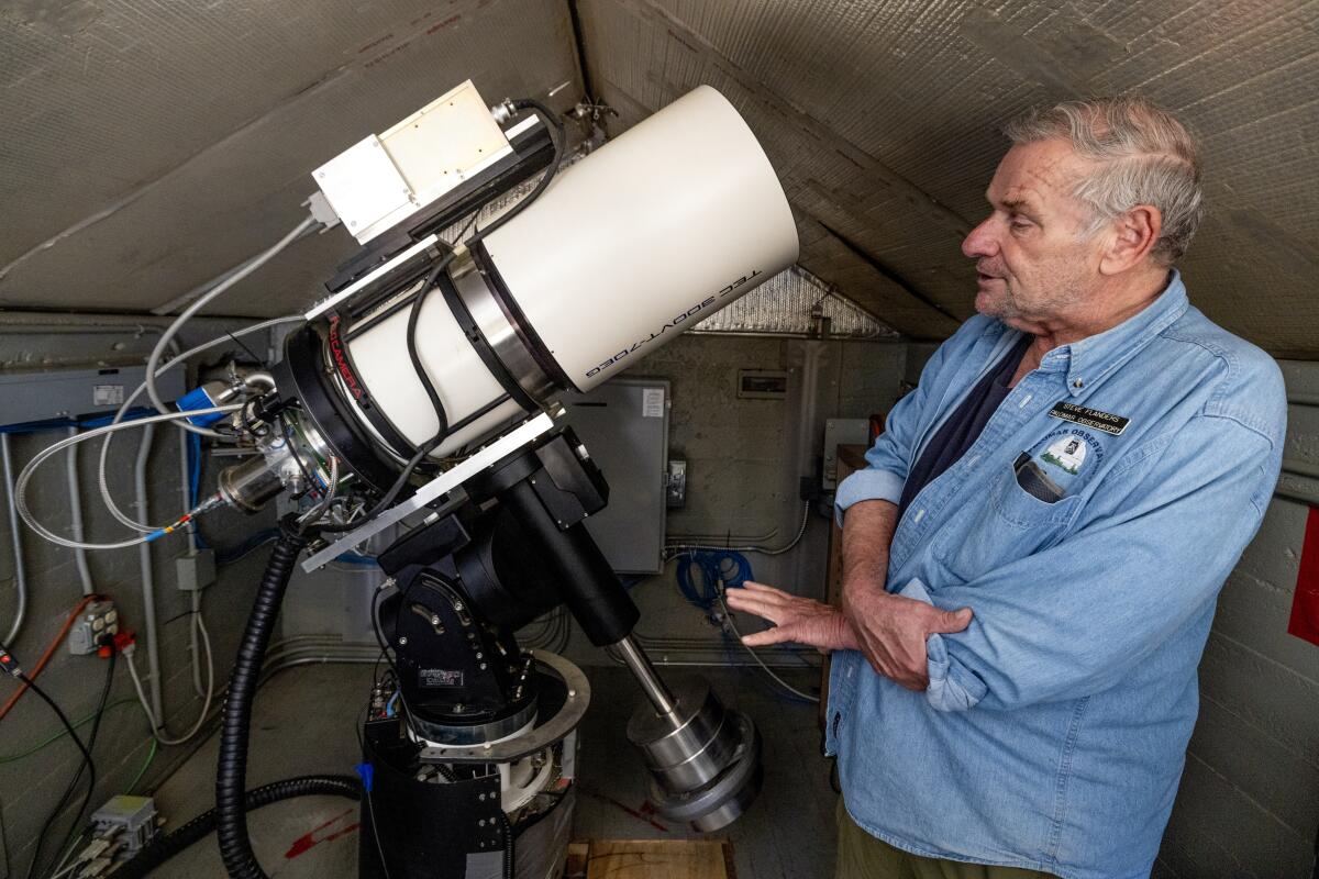 Steve Flanders shows the Gattini-IR telescope inside a small building at the Palomar Observatory.