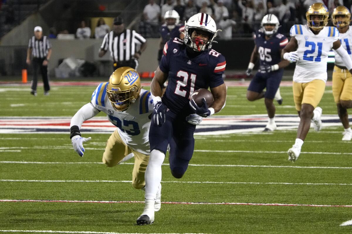 Arizona geri koşuyor Rayshon Luke, dördüncü çeyrekte 66 yardlık bir resepsiyon için UCLA defans oyuncusu Ty Lee'den ayrılıyor.