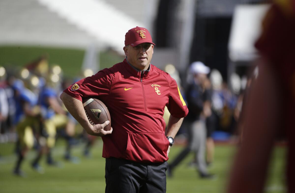 USC interim head coach Clay Helton watches his players during warmups before the UCLA game.