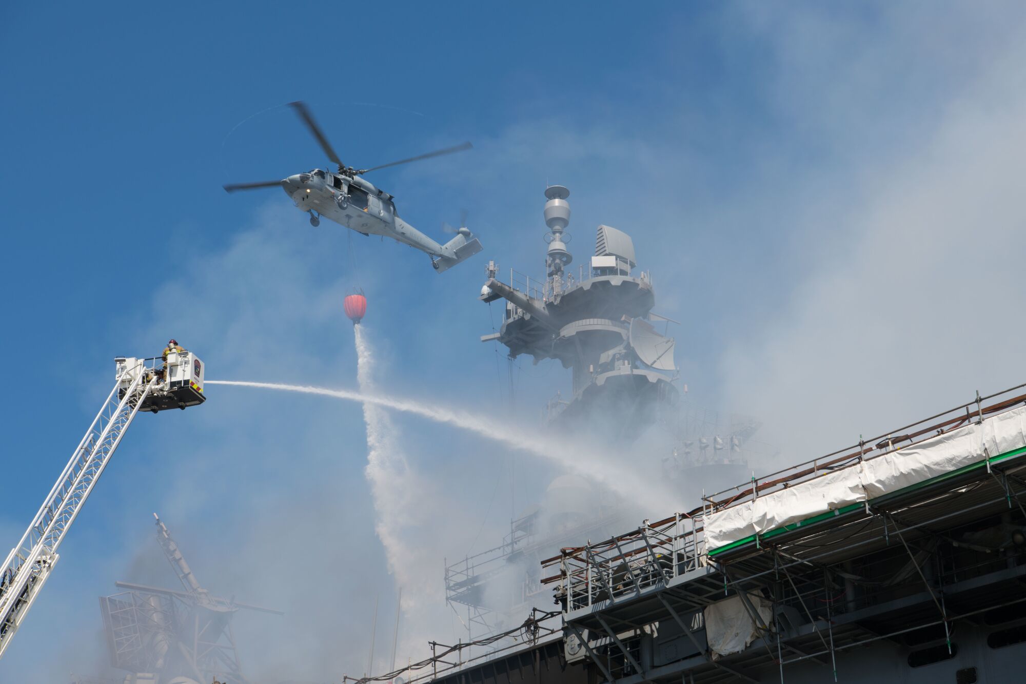 A helicopter combats a fire aboard the amphibious assault ship USS Bonhomme Richard.