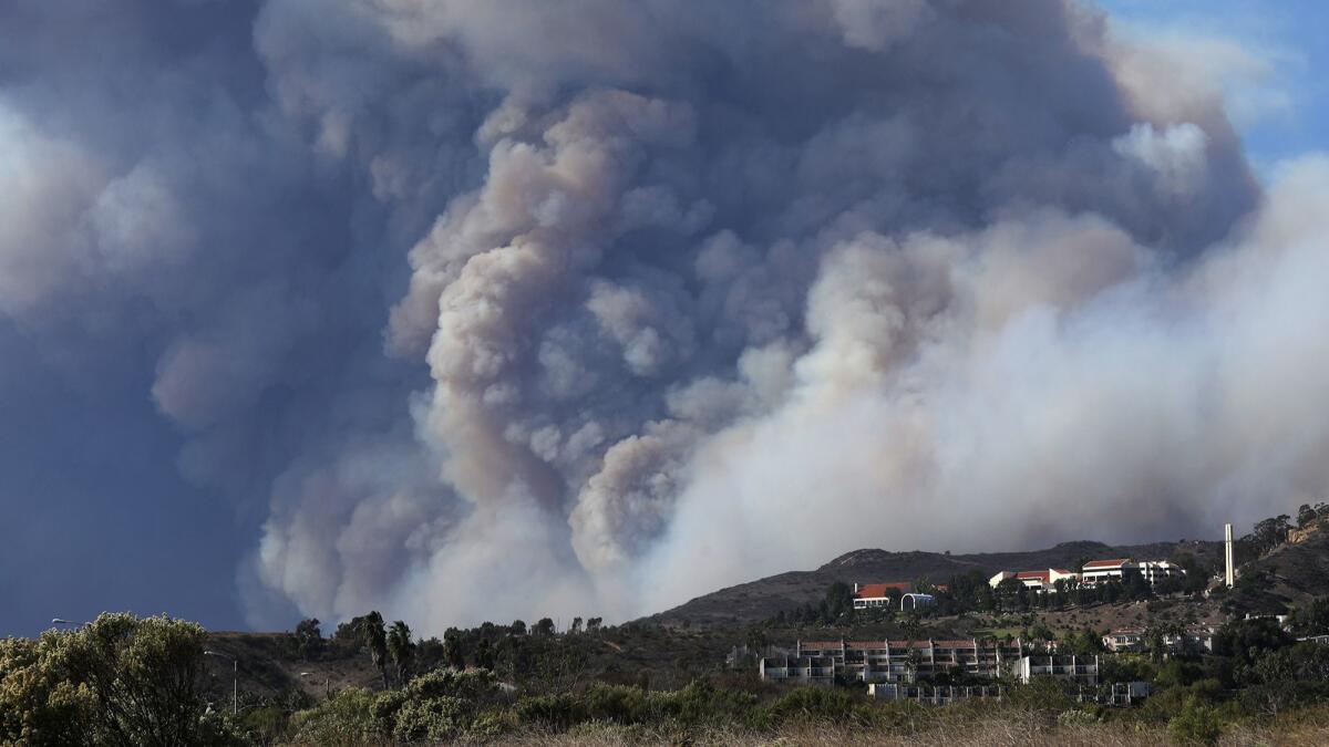Pepperdine University and other structures sit before the plumes of the Woolsey Fire.