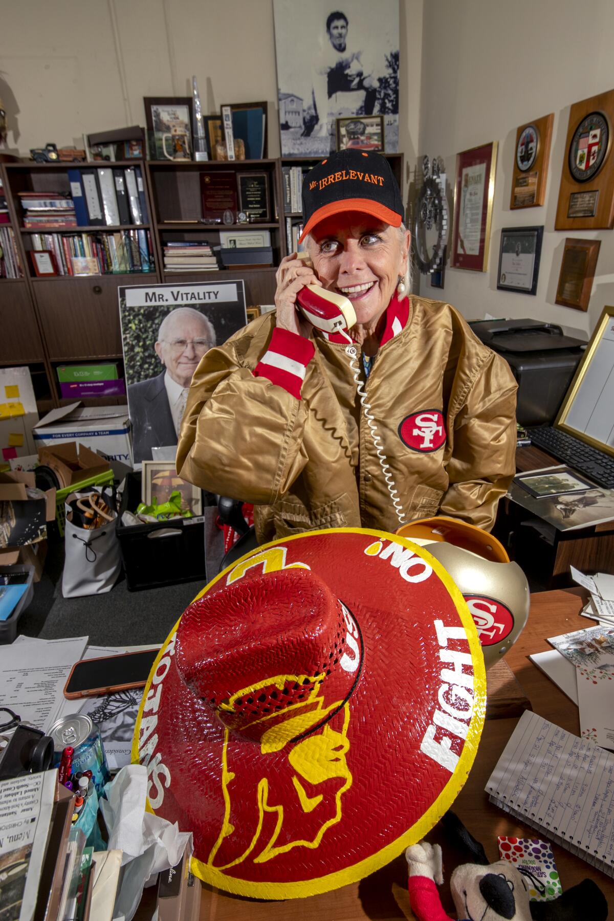 Melanie Salata-Fitch pretends to take a call from a phone shaped like a San Francisco 49er football helmet.
