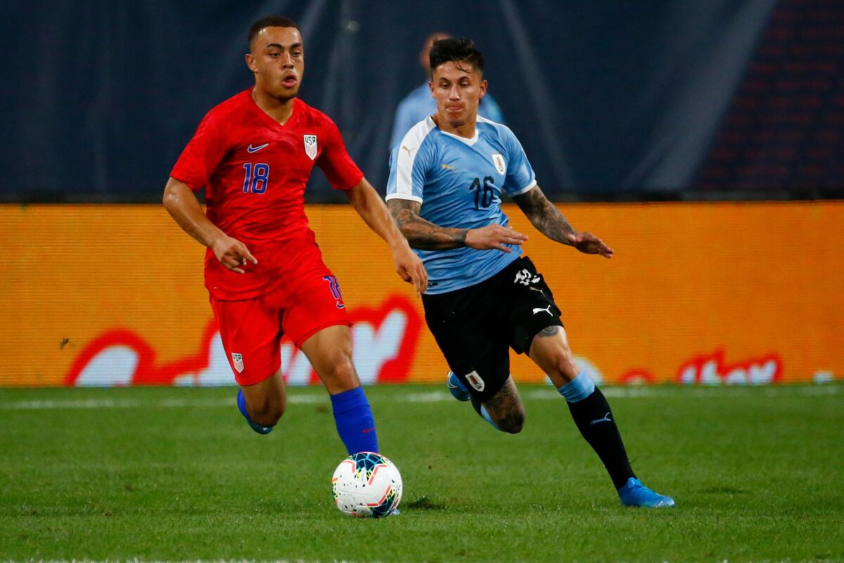 U.S. defender Sergiño Dest controls the ball ahead of Uruguay's Brian Rodriguez.