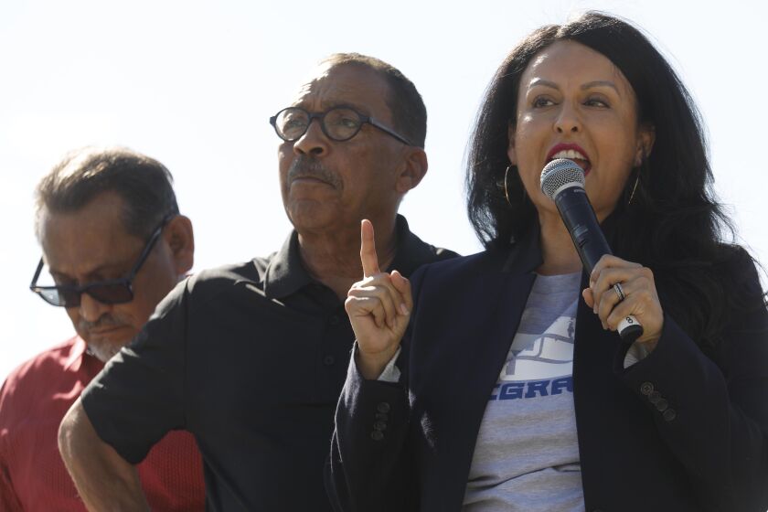 LOS ANGELES, CA - NOVEMBER 9, 2019 - - Los Angeles City Council Member Nury Martinez, right, addresses the crowd as Los Angeles City Council President Herb Wesson, center, and Los Angeles City Council member Gil Cedillo listen at the, “Rally for Justice Immigrant Rights and Equality - 25 years beyond Proposition 187,” at the Los Angeles State Historic Park in Los Angeles on November 9, 2019. Prop. 187 aimed to block undocumented immigrants from using non-emergency health care, public education and other services in the State of California. Federal courts denied it from ever being implemented. Congresswoman Lucille Roybal Allard, Los Angeles Mayor Eric Garcetti, and many other politicians and activists spoke at the rally. (Genaro Molina / Los Angeles Times)