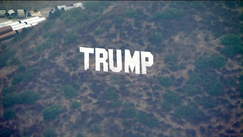 A sign in the style of the Hollywood sign that says "Trump"