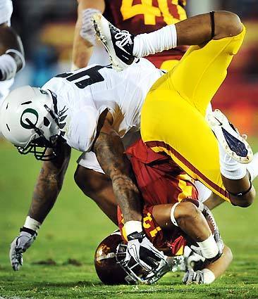 USC's Robert Woods is upended by an Oregon defender on a kickoff return in the second quarter of a Pacific 10 Conference football game on Saturday at the Coliseum. Oregon won the game, 53-32.
