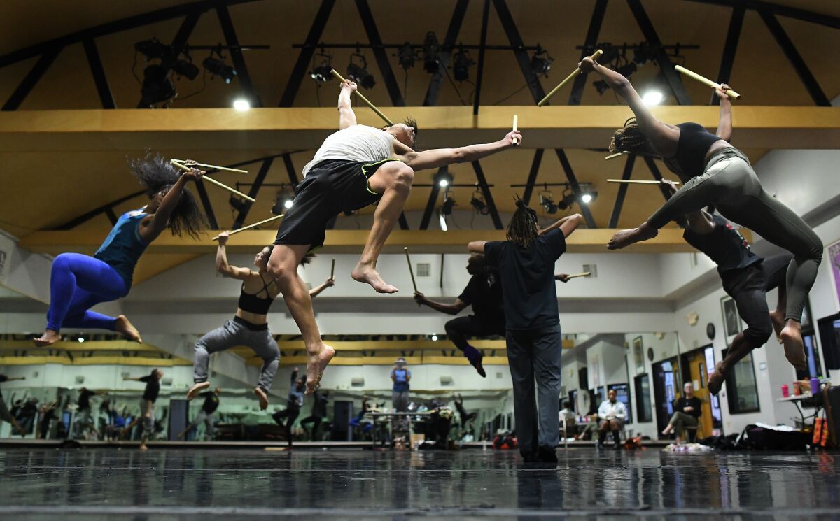 Dancers at Lula Washington Dance Theatre leap in the air in rehearsal.