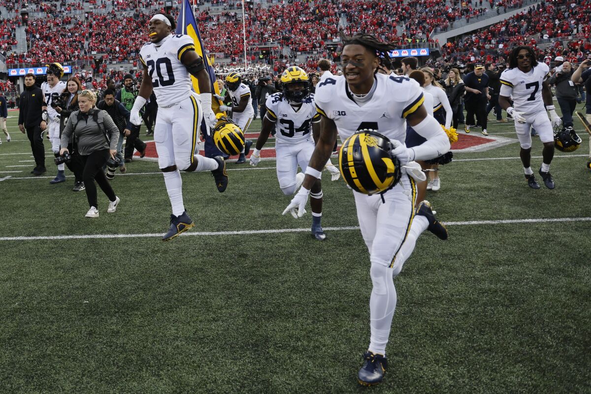 Michigan players celebrate their win over Ohio State after an NCAA college football game on Saturday, Nov. 26, 2022, in Columbus, Ohio. (AP Photo/Jay LaPrete)