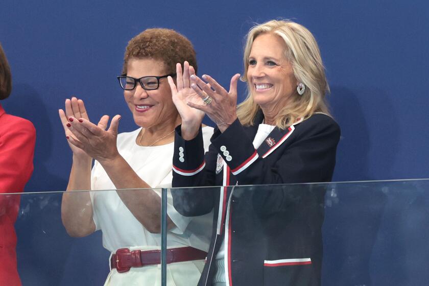 L.A. mayor Karen Bass, left, and First Lady Jill Biden clap before a women's water polo match on July 24.