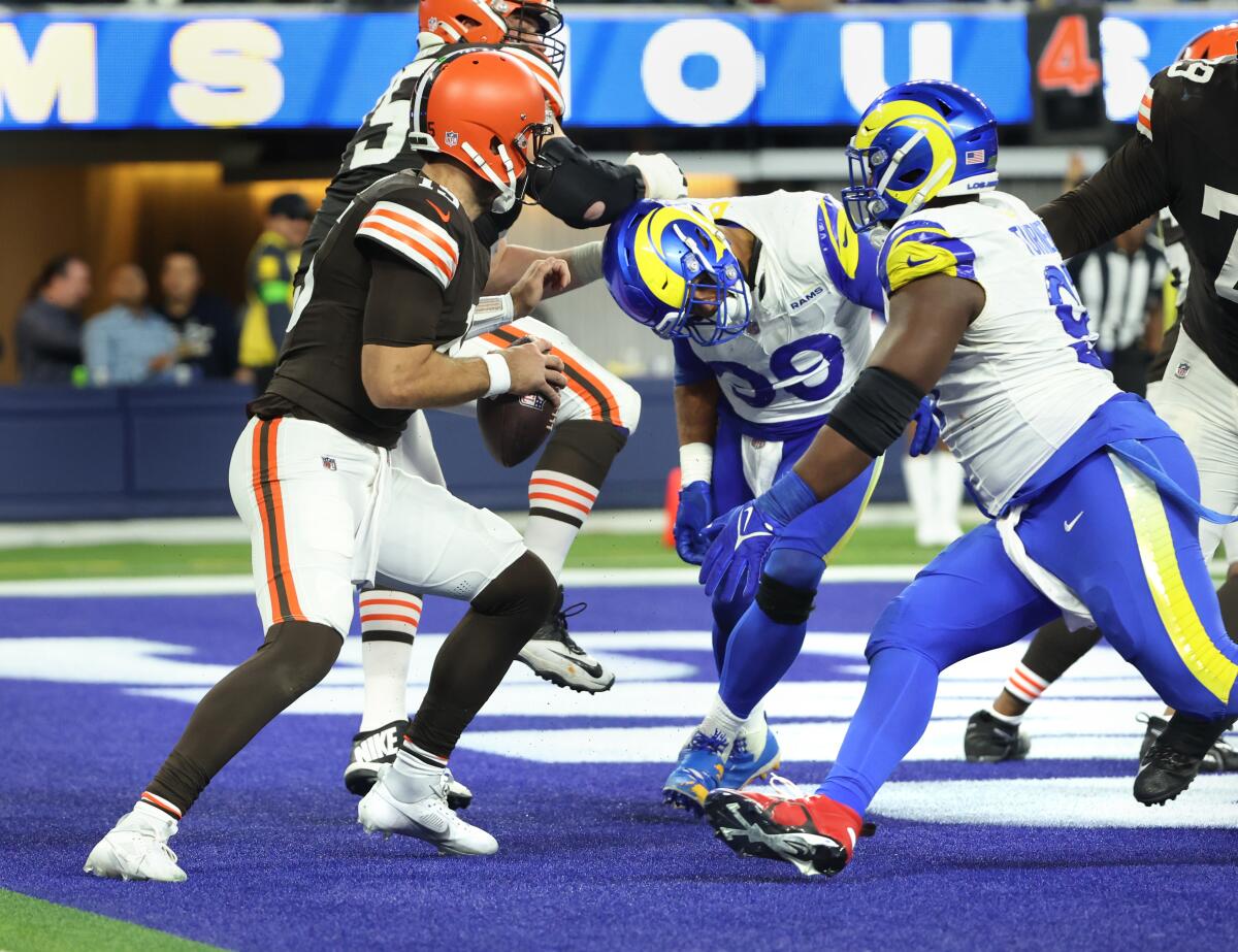 Browns quarterback Joe Flacco is about to be sacked by Rams Aaron Donald and Kobie Turner, right, for a safety.