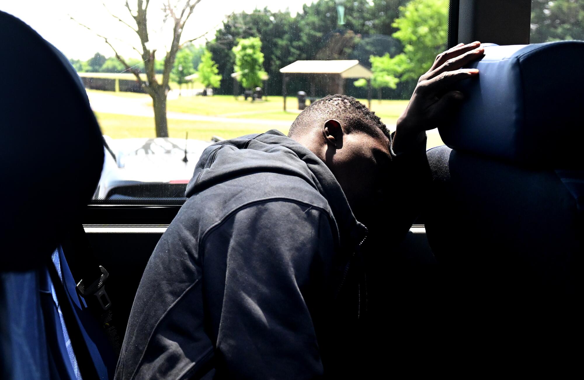 A jet-lagged Dennis Kasumba tries to sleep on a bus in Frederick, Md., headed to Trenton, N.J.