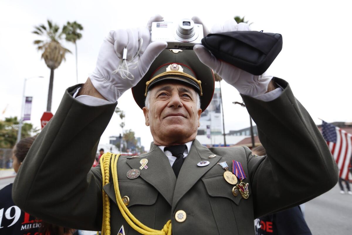 Vahe Mesropyan, an Armenian army colonel, takes photos as thousands march west on Sunset Blvd. at the beginning of a six mile march marking 100th anniversary of Armenian Genocide.