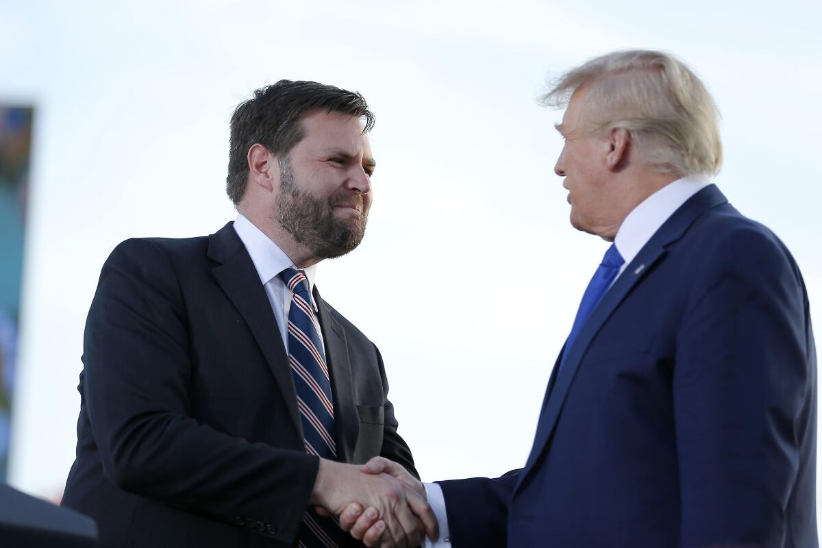 Ohio Senate candidate J.D. Vance, left, greets former President Trump at a rally in Delaware, Ohio. 