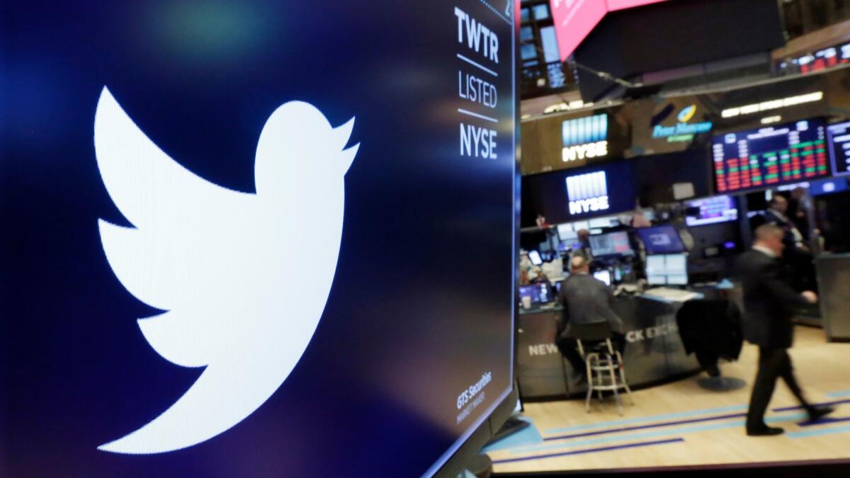 The logo for Twitter is displayed above a trading post on the floor of the New York Stock Exchange.