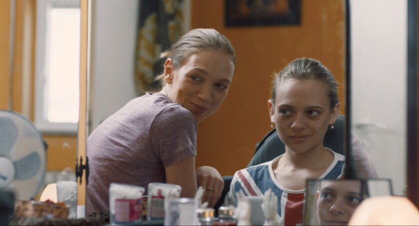 A mother and her teenage daughter look at themselves in a mirror in the movie "Asia."