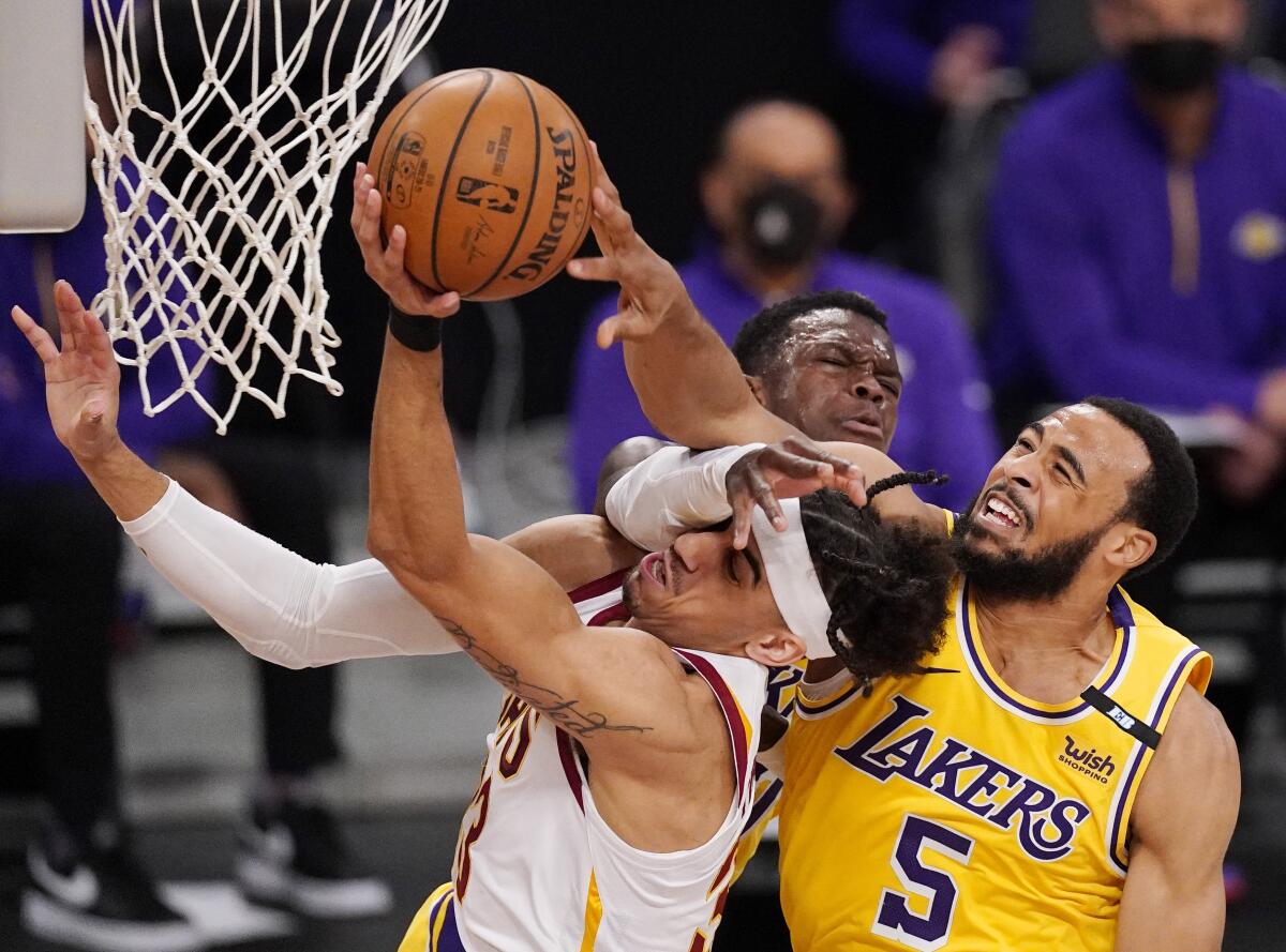 Cavaliers guard Brodric Thomas is fouled on a layup against Lakers guards Dennis Schroder, center, and Talen Horton-Tucker.