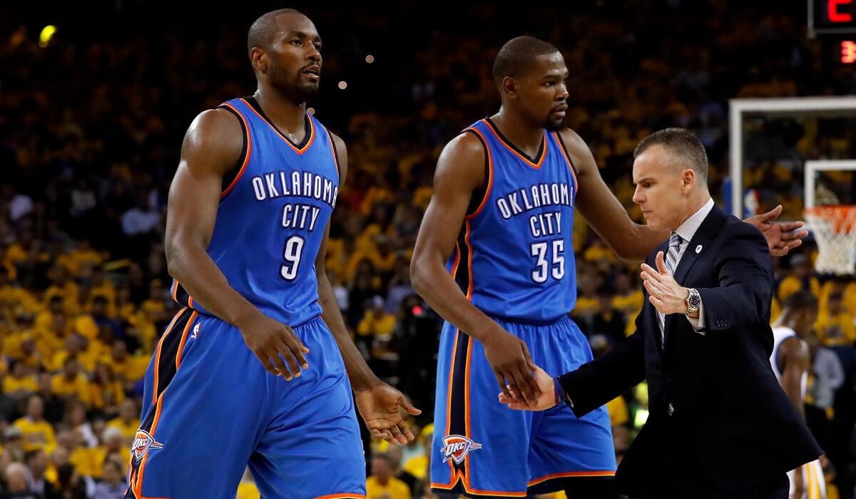 Oklahoma City Thunder Coach Billy Donovan high fives Serge Ibaka, left, and Kevin Durant during Game 1 of the NBA Western Conference Finals against the Golden State Warriors on Monday.