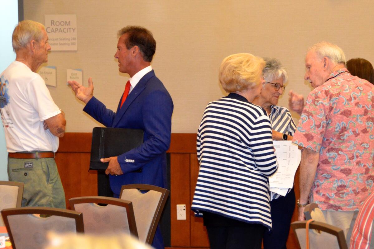 Candidates Tom Miller, left and Joy Brenner, center left, talk to OASIS attendees following forum on Friday.