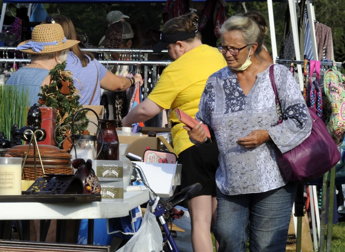 A crowd looks through items at the World's Longest Yard Sale, which stretches from Alabama to Michigan, at its southernmost point in Gadsden, Ala., on Thursday, Aug. 6, 2020. Promoters considered canceling the four-day sale because of the coronavirus pandemic but decided to go ahead with the event, now in its 34th year. (AP Photo/Jay Reeves)