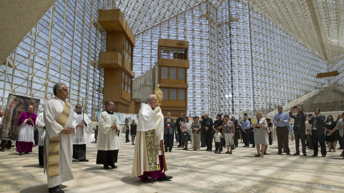 Bishop Kevin Vann guides the Eucharistic procession through Christ Cathedral in Garden Grove in May. Multiple Masses in Vietnamese, Spanish, English and Chinese are held at the cathedral on Sundays.