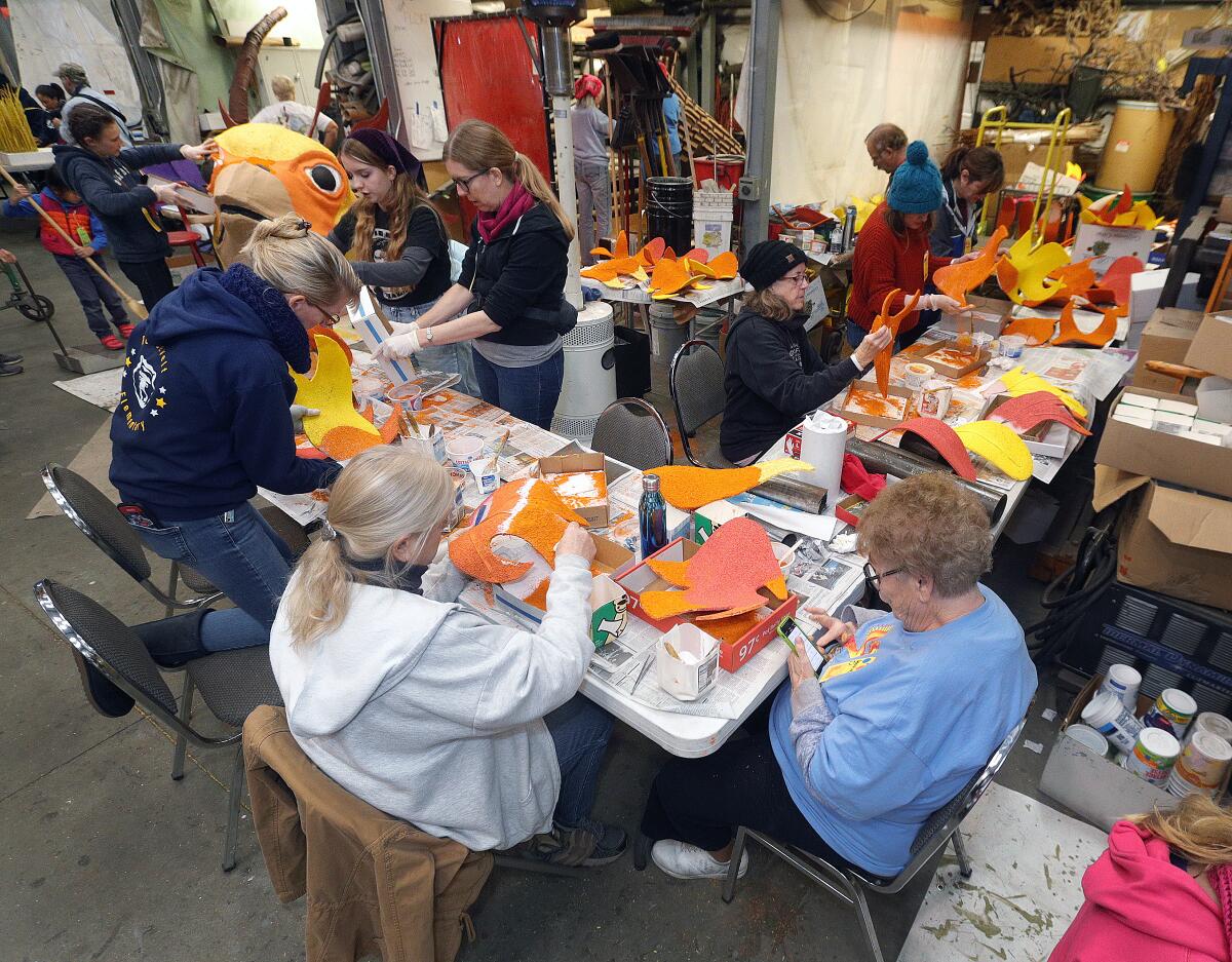 Volunteers work on the details of the float for the Burbank Tournament of Roses Assn.'s float entry, called "Rise Up," on Friday. The theme is based on the rise of a phoenix to represent the recovery after the California wildfires over the past two years.