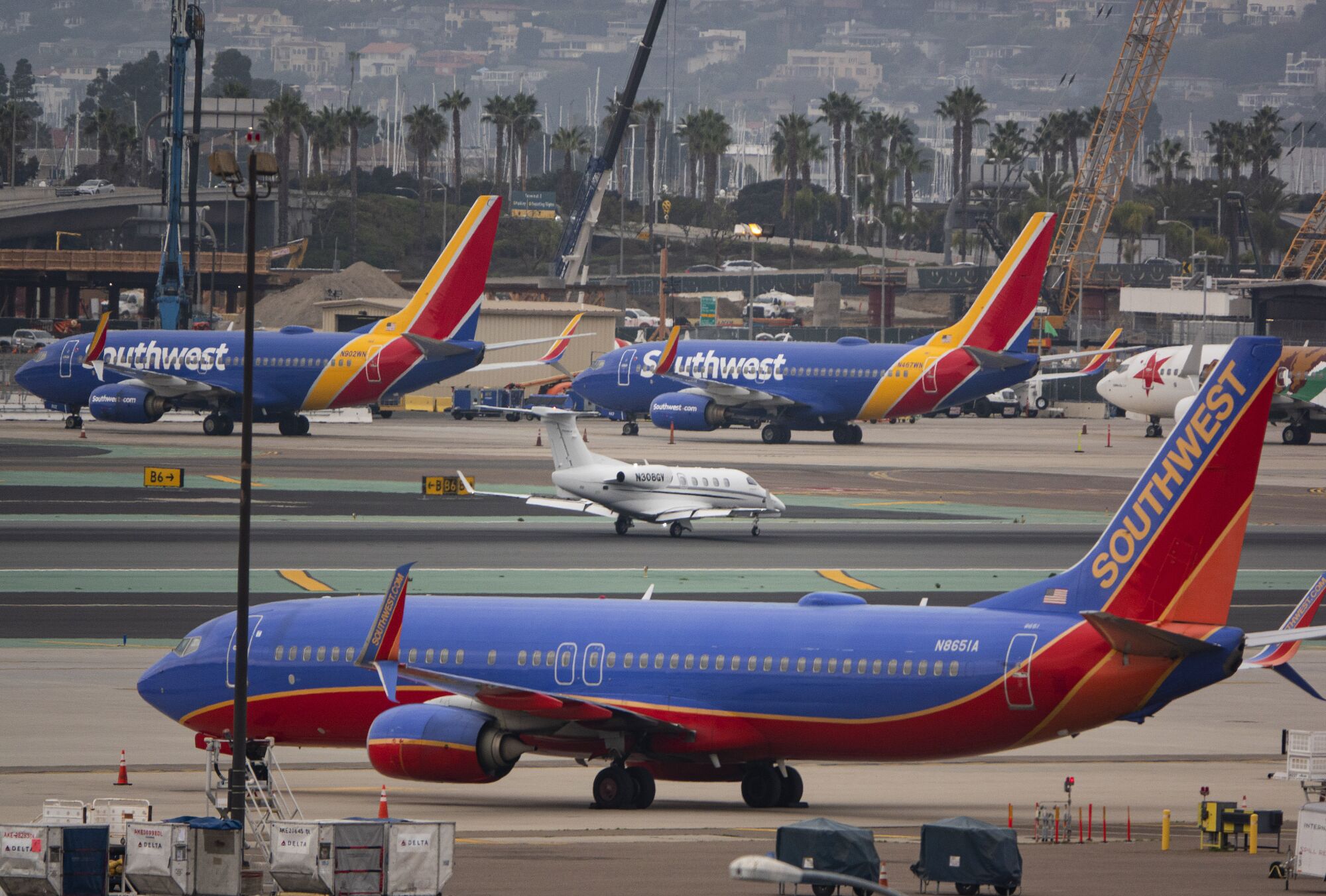 Southwest jets are parked on each side of the runway at the San Diego airport after thousands of flight cancellations. 