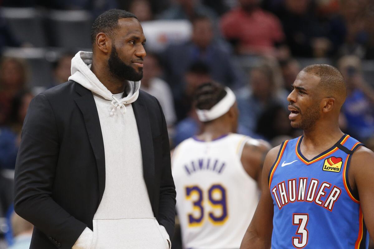 Los Angeles Lakers forward LeBron James, left, talks with Oklahoma City Thunder guard Chris Paul.