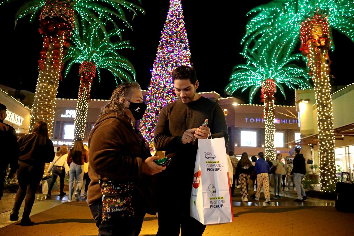 Shoppers out at the Citadel Outlets in Commerce with lighted palm trees in the background