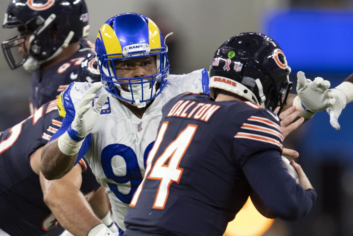 FILE- In this Sunday, Sept. 12, 2021, file photo, Los Angeles Rams defensive end Aaron Donald (99) tackles Chicago Bears quarterback Andy Dalton (14) during an NFL football game in Inglewood, Calif. As Donald, now 30, closes in on the franchise's career sacks record this week, the three-time NFL Defensive Player of the Year says the only difference in his game with age is the recovery time necessary for minor injuries. (AP Photo/Kyusung Gong, File)