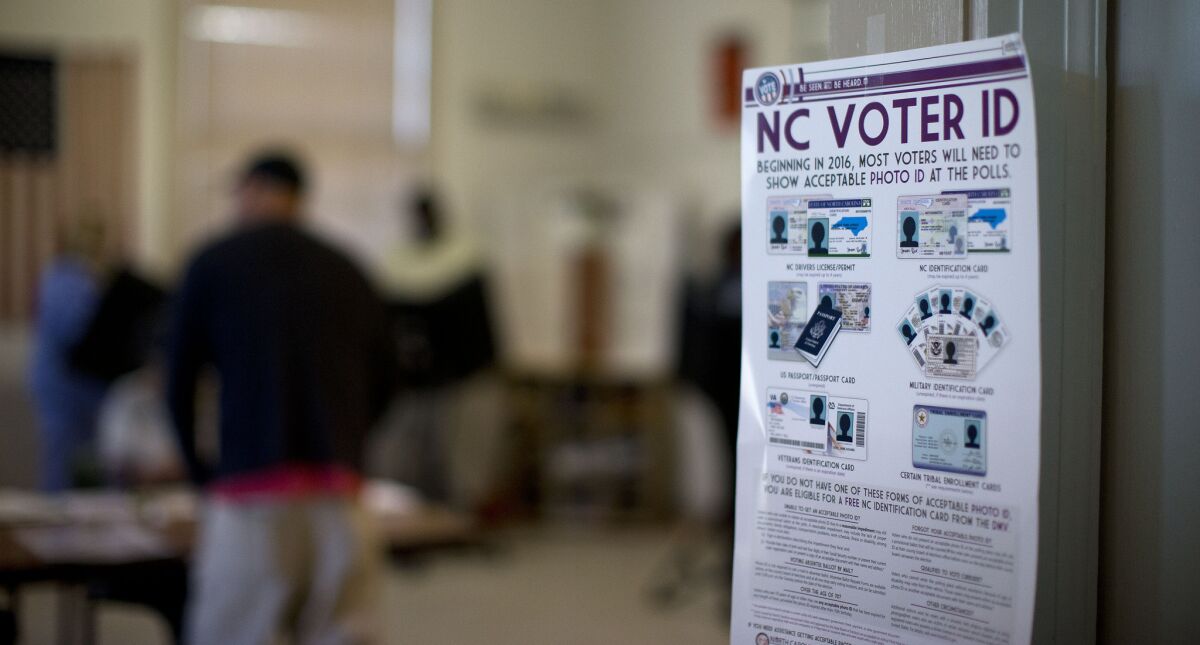 Voter ID rules are posted at the door of the Alamance Fire Station on March 15 in Greensboro, N.C.