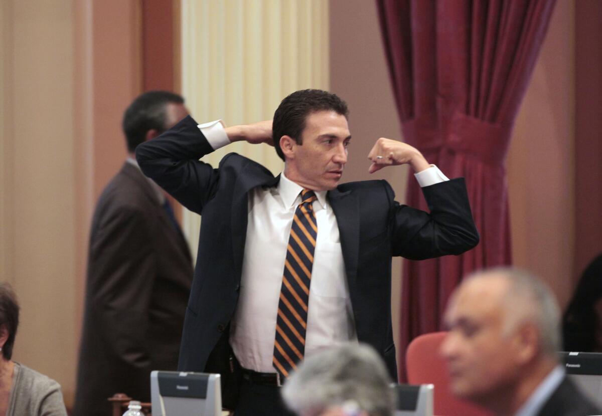 State Sen. Michael J. Rubio (D-Shafter) stretches during a lull in the legislative action at the Capitol last year. He announced his resignation on Friday.