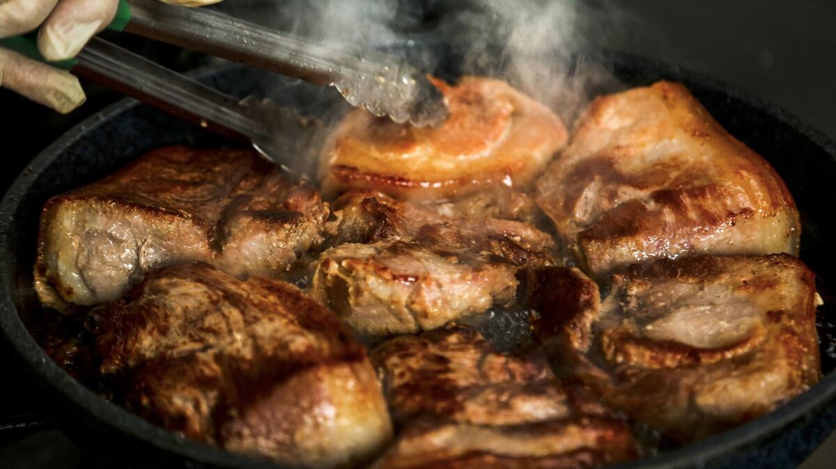 Before meat is cooked, Hue Phan washes it four times to release residue, then bathes it in a Coco Rico soda rinse to seal in flavor. (Mark Boster / Los Angeles Times)