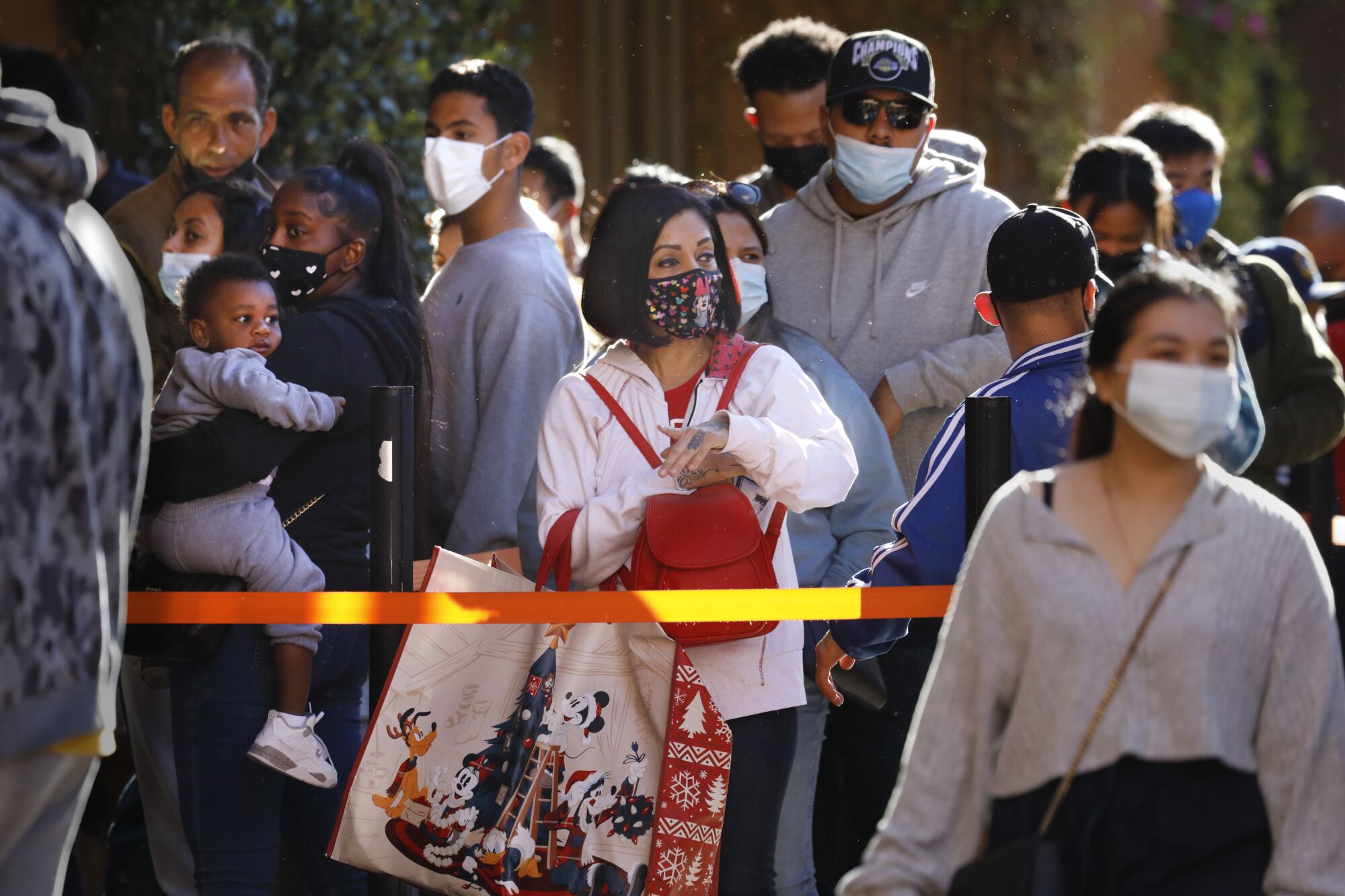 Jacquelin Reyes, of Los Angeles, (with red bag) waits in line at the Nike Store at Citadel Outlets in Los Angeles. 