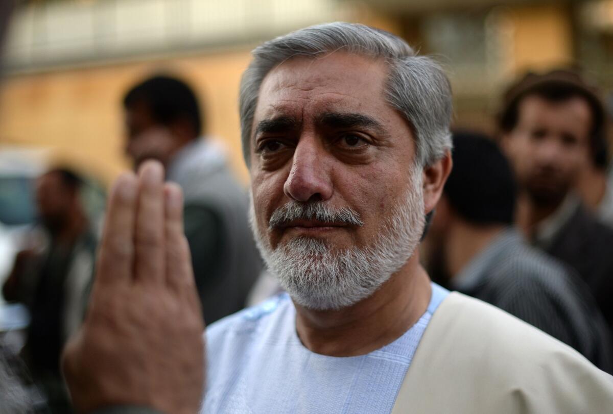Afghan presidential candidate Abdullah Abdullah greets supporters during a news conference at his residence in Kabul. Afghanistan's election will go to a runoff vote between Abdullah, who is a former foreign minister, and ex-World Bank economist Ashraf Ghani.