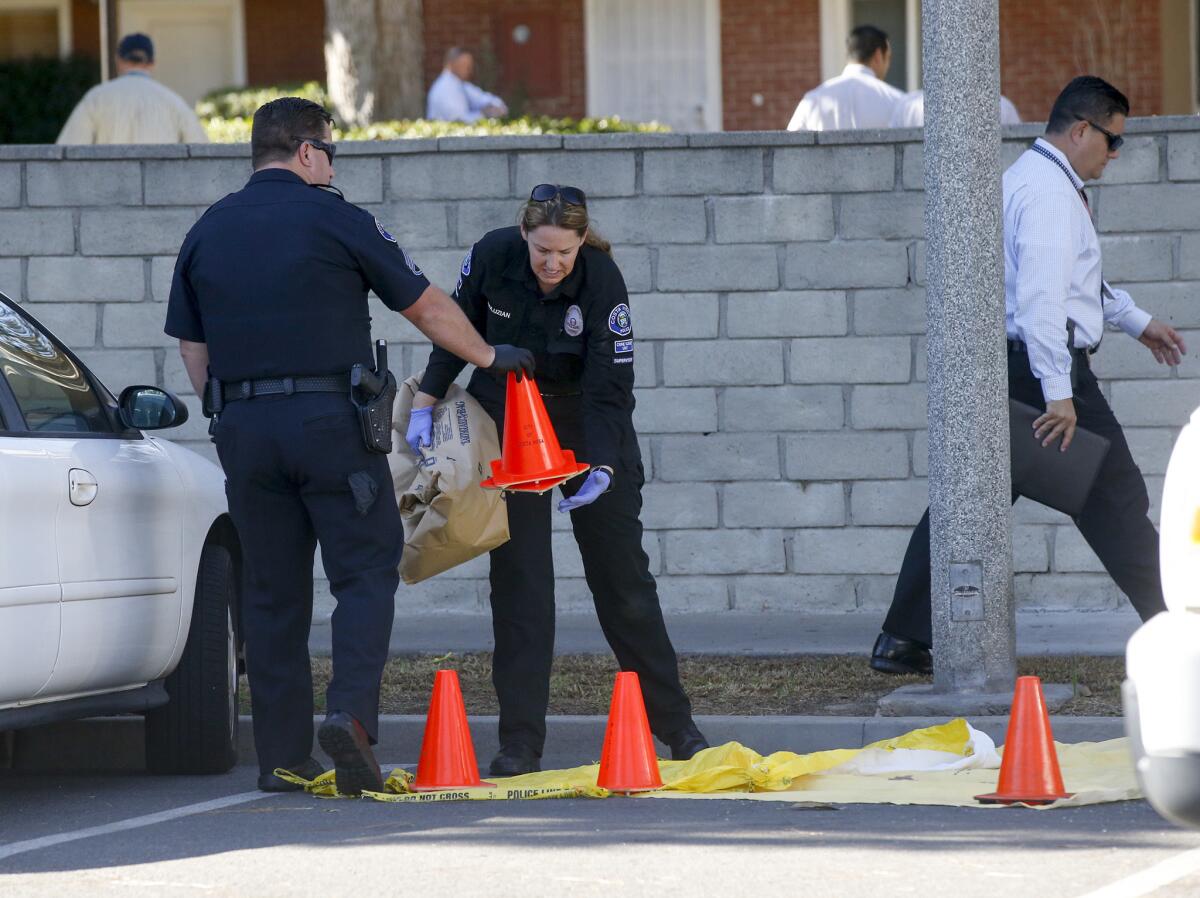 Police collect possible evidence in the 2300 block of Vanguard Way in Costa Mesa where a man's body was found Wednesday morning.