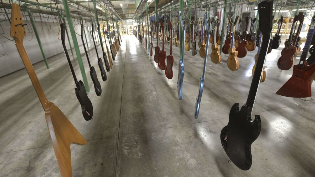 New guitars hang, waiting to have final finish applied at the Gibson guitar manufacturing plant in Nashville. (Christopher Berkey / For The Times)