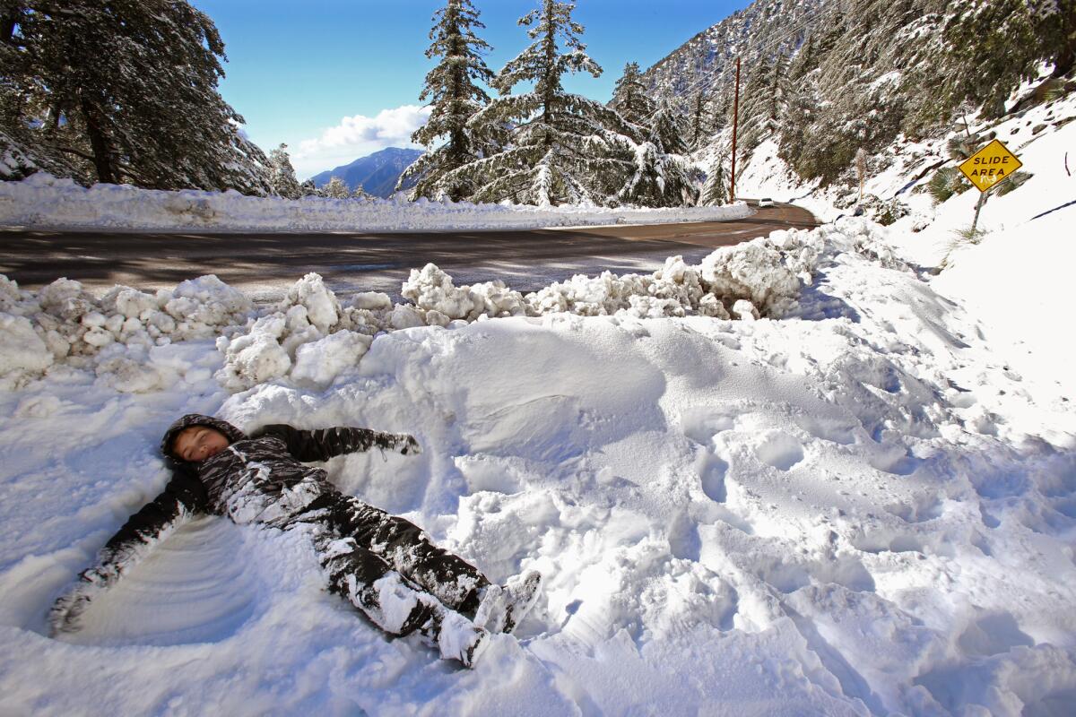 Gavin Strini, 8, from Corona, makes a snow angel alongside Mt. Baldy Road at Mt. Baldy on Jan. 7.