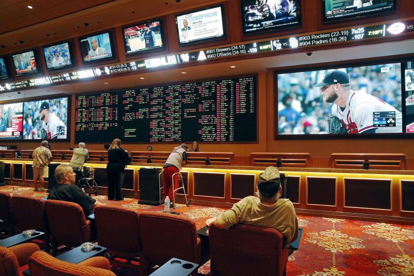 FILE - In this Monday, May 14, 2018 file photo, people make bets in the sports book at the South Point hotel and casino in Las Vegas. State regulators say Nevada gambling revenue decreased 3 percent in January 2019 from the same time last year. The Nevada Gaming Control Board on Thursday, Feb. 28, 2019, reported casinos brought in about $984.6 million last month. (AP Photo/John Locher, File)