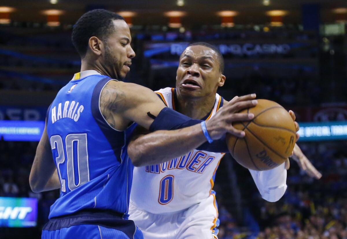 Thunder guard Russell Westbrook is fouled by Mavericks guard Devin Harris on a drive to the basket in the third quarter Thursday night.