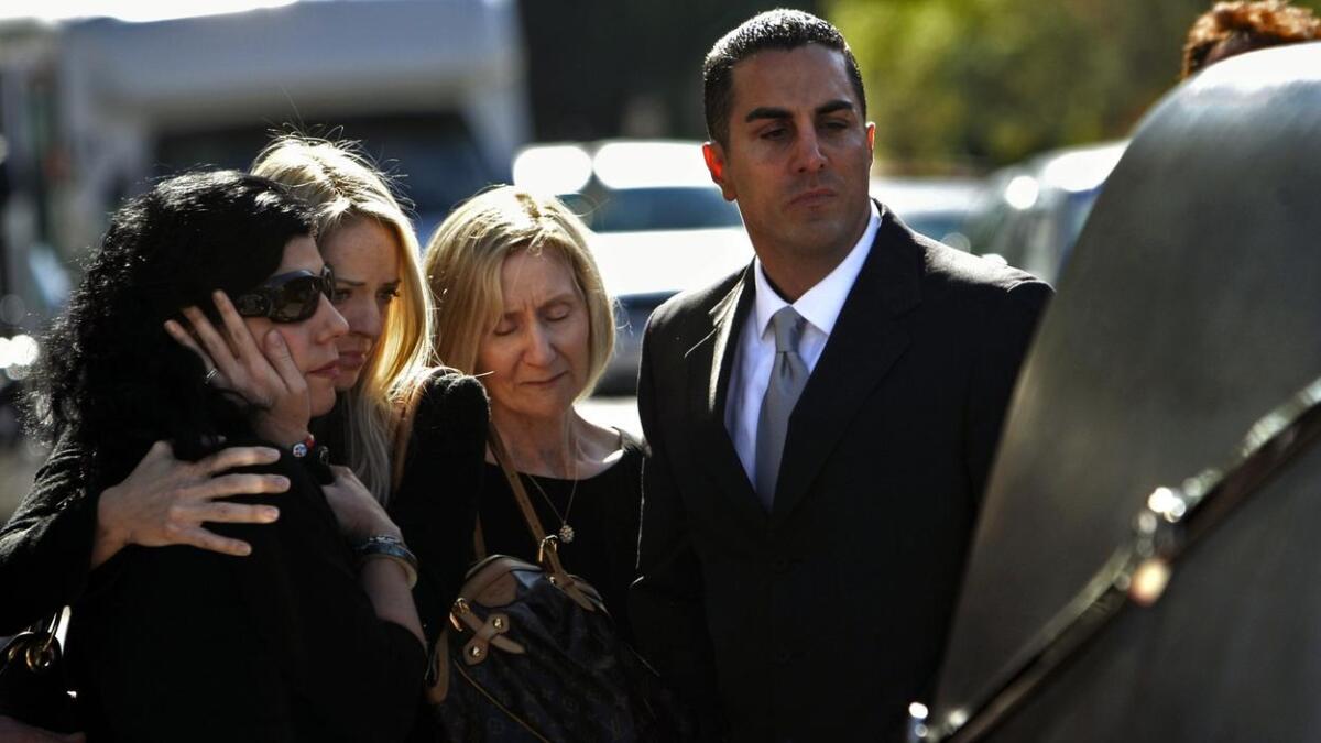 Mariann Gatto, left, Danielle Gatto, Isolde Gatto and Assemblyman Mike Gatto look at the hearse carrying Joseph Gatto's casket at Our Mother of Good Counsel Catholic Church in Los Feliz.