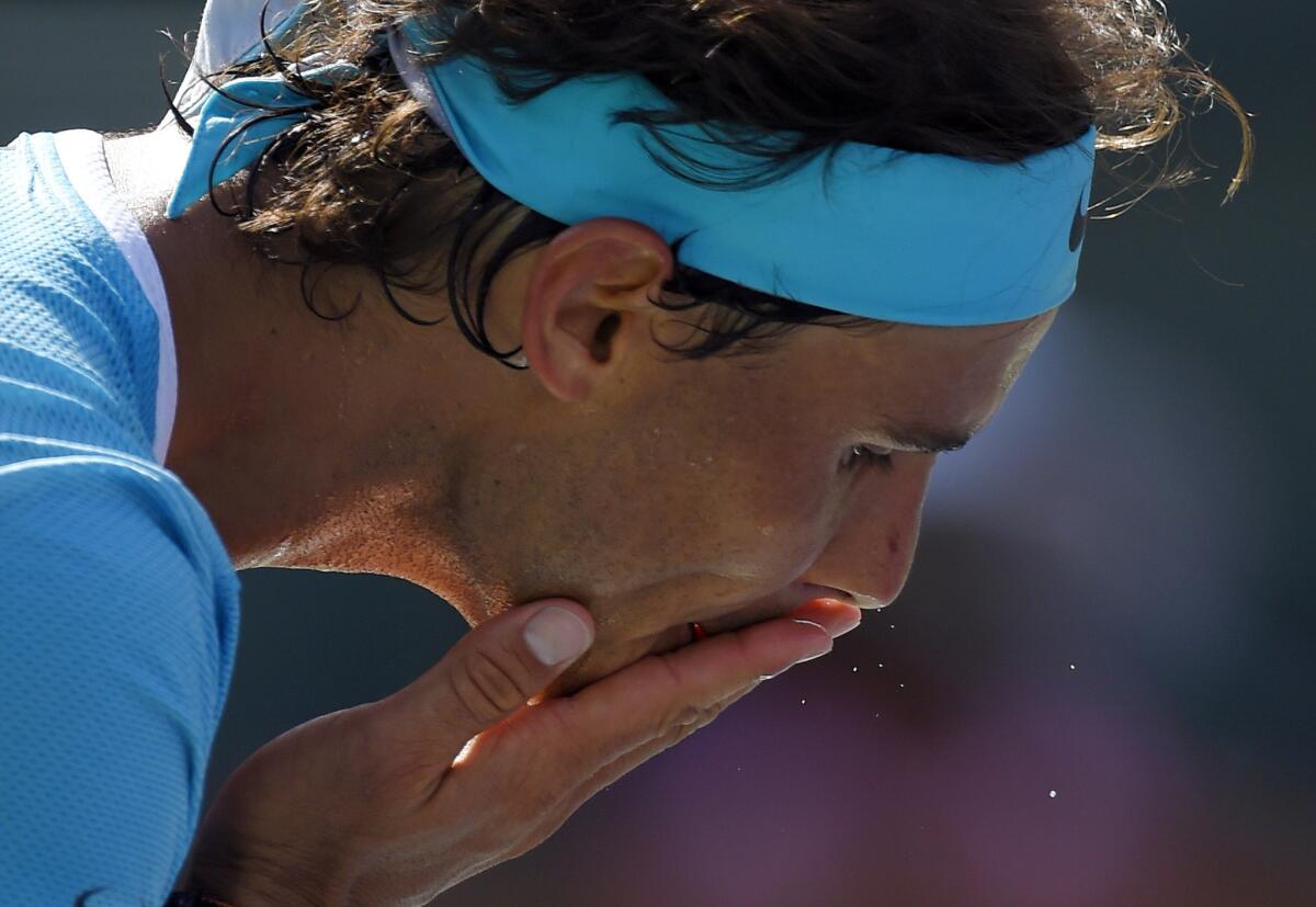 Rafael Nadal of Spain wipes sweat from his face before serving to Novak Djokovic of Serbia during a semifinal match of the BNP Paribas Open on March 19.