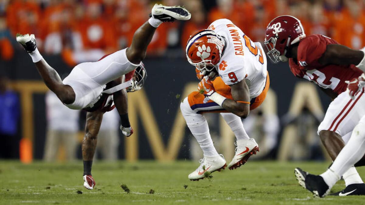 Clemson running back Wayne Gallman (9) is brought down by Alabama defensive back Tony Brown (left). To see more images from the game, click on the photo above.