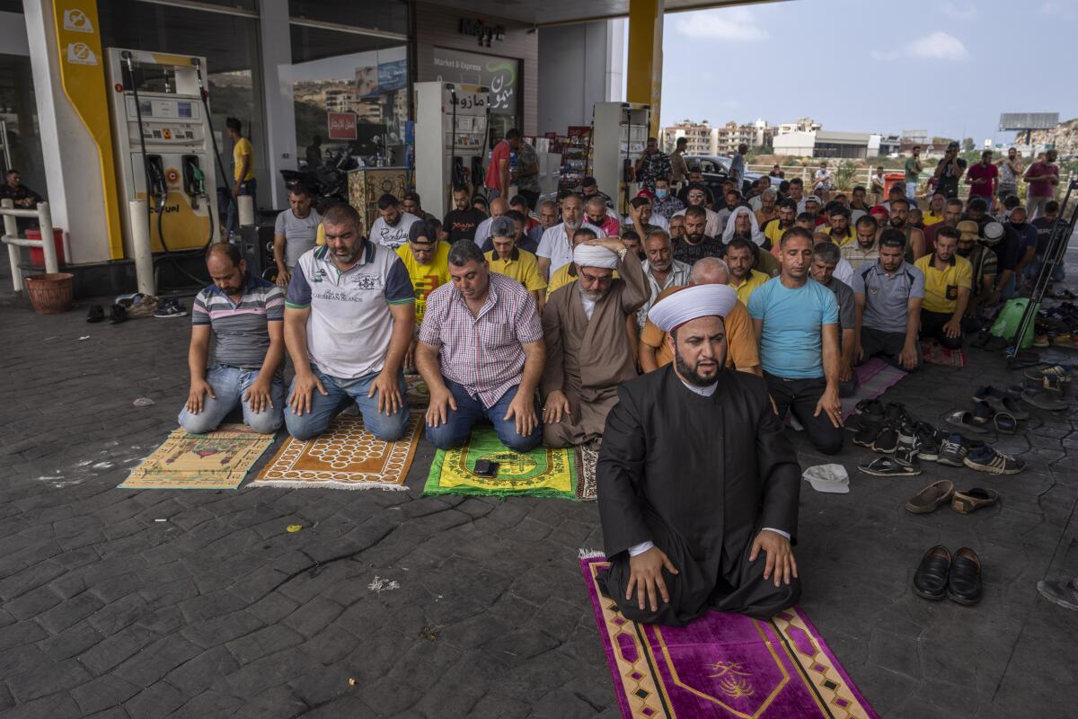 Muslim worshippers pray during Friday prayers at a gas station to protest severe fuel shortages that Lebanon has been witnessing for weeks, in the coastal town of Jiyeh, south of Beirut, Lebanon, Friday, Sept. 3, 2021. Lebanon is mired in a devastating economic and financial crisis, the worst in its modern history. A result of this has been crippling power cuts and severe shortages in gasoline and diesel that have been blamed on smuggling, hoarding and the cash-strapped government’s inability to secure deliveries of oil products. (AP Photo/ Hassan Ammar)