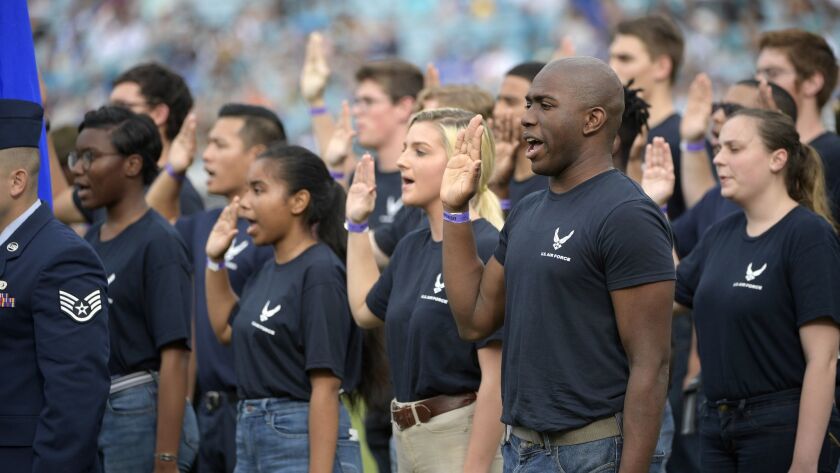U.S. military recruits take part in a swearing-in ceremony during halftime of an NFL game in December.