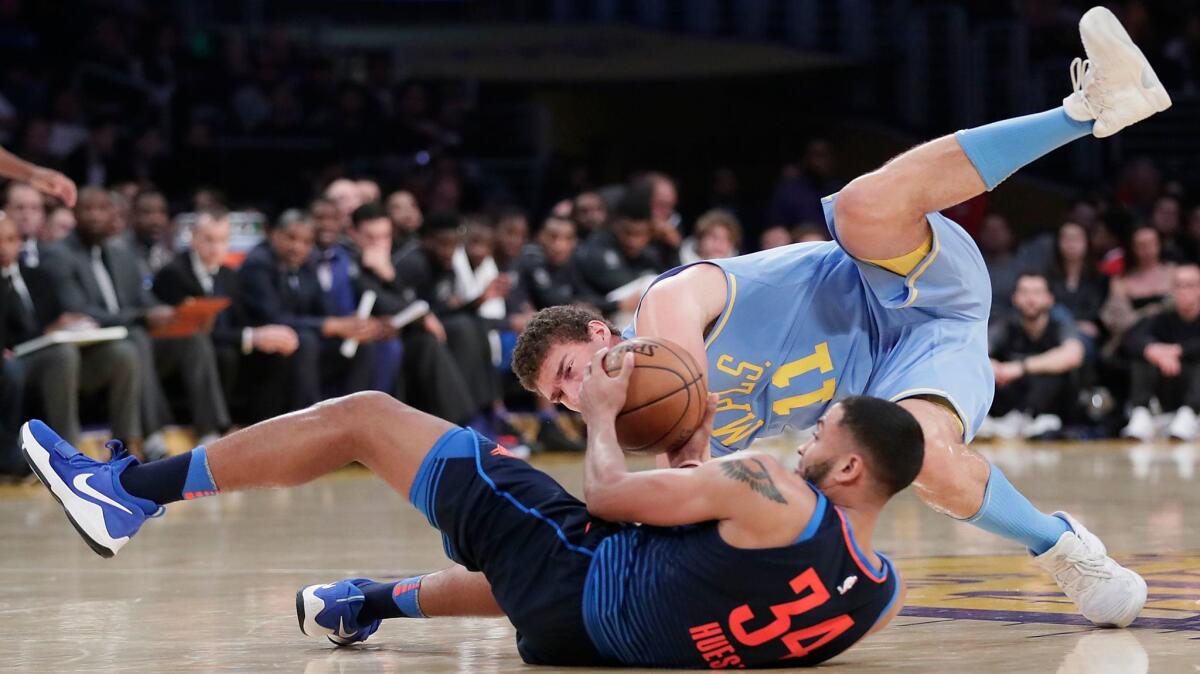 Lakers center Brook Lopez tumbles over Oklahoma City guard Josh Huestis in pursuit of a loose ball on Jan. 3.