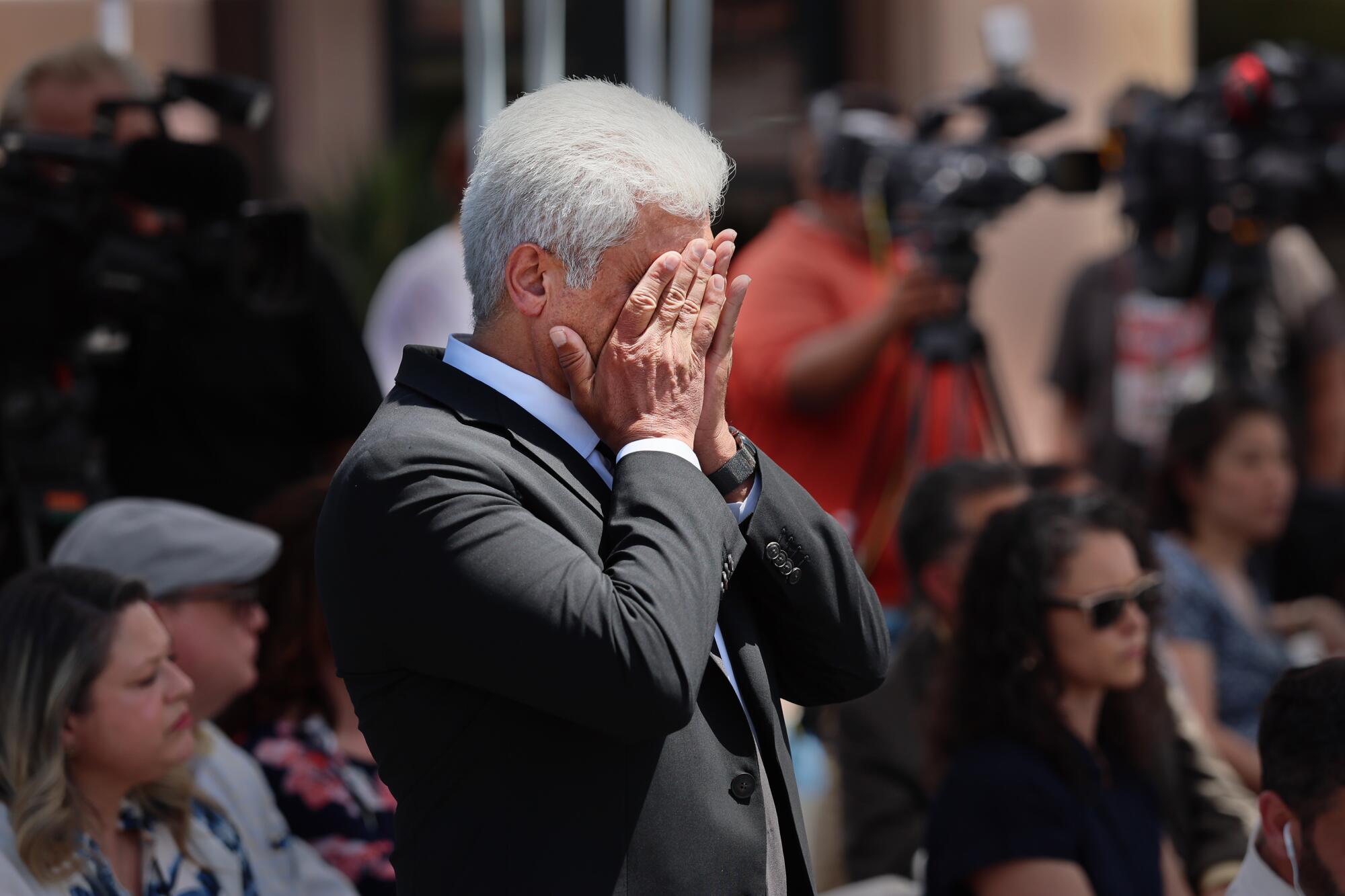 Dr. Maher Abdallah, director of American Reproductive Centers, wipes his eyes at a news conference.