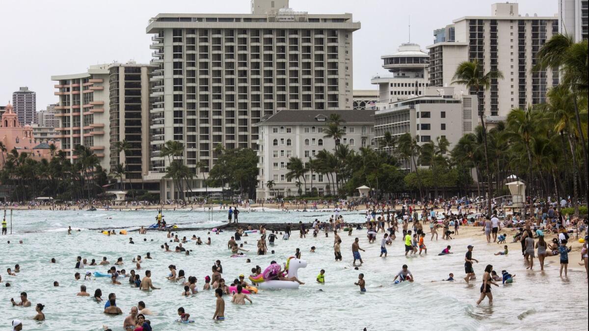 Despite the beaches being closed because of the threat of Hurricane Lane, people play in the waters at Waikiki Beach in Hawaii.