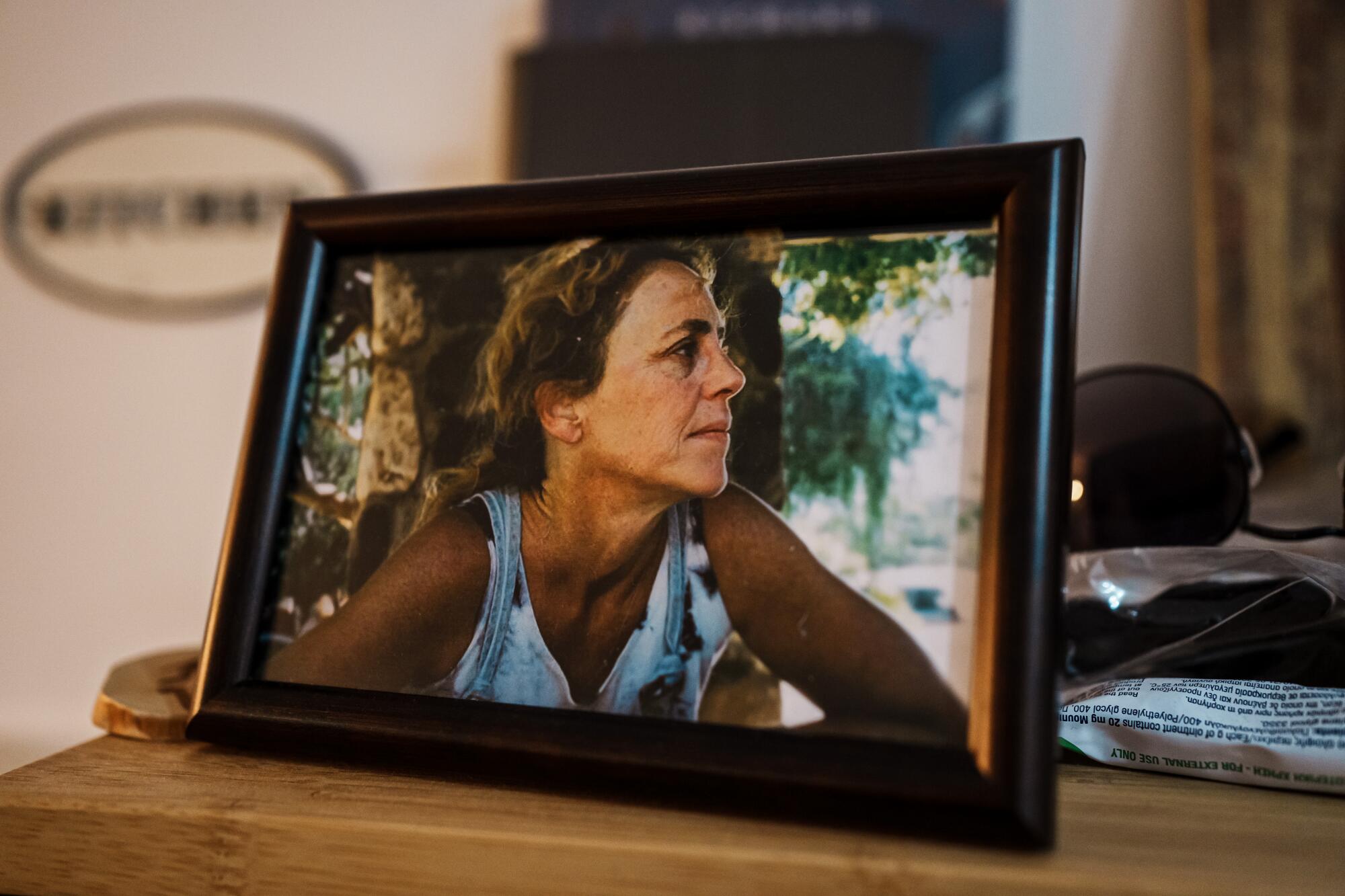 A framed photograph of a woman in a patterned white top, looking to the right 